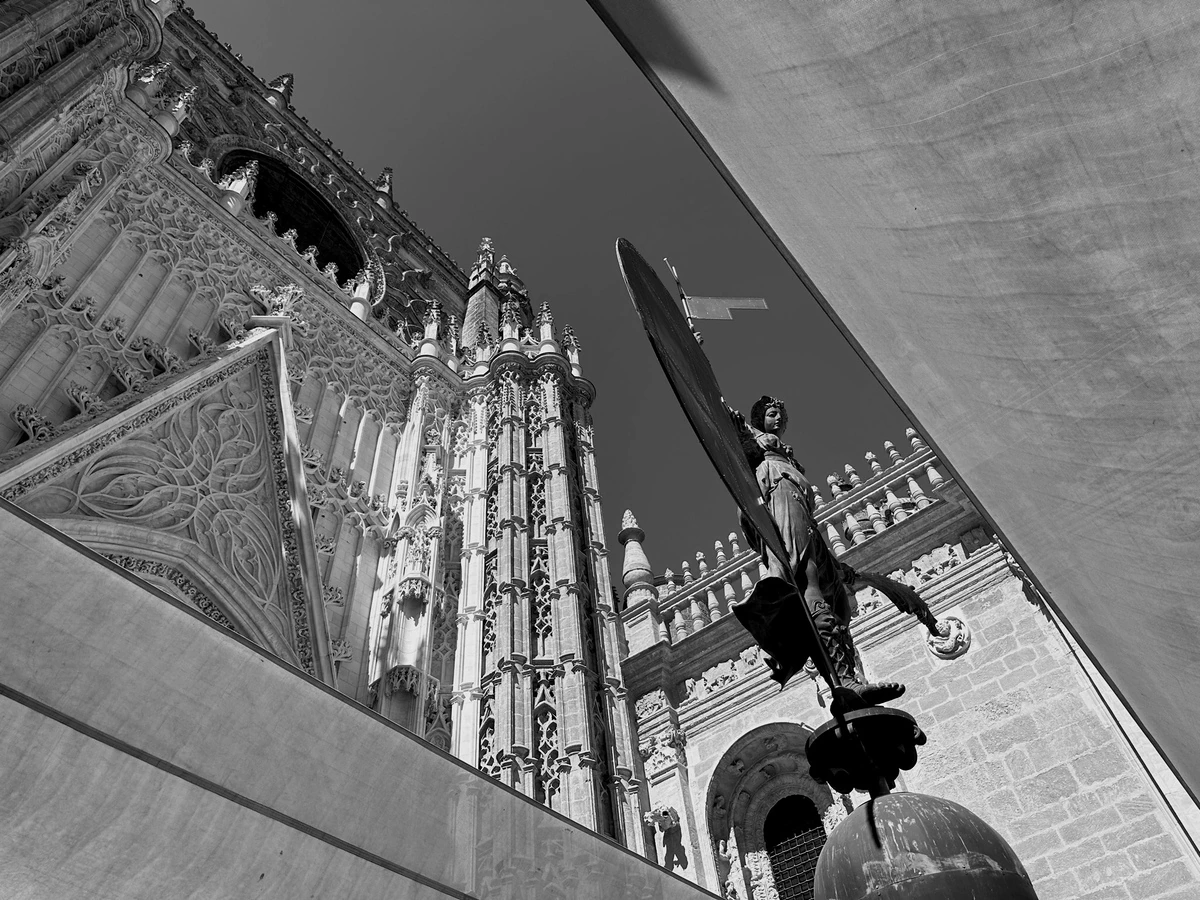 A cathedral and a statue seen through angular architectural framing